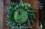 a wreath made of various green plants and leaves, with a large green circular sign displaying the word "Lucky" in the center.
