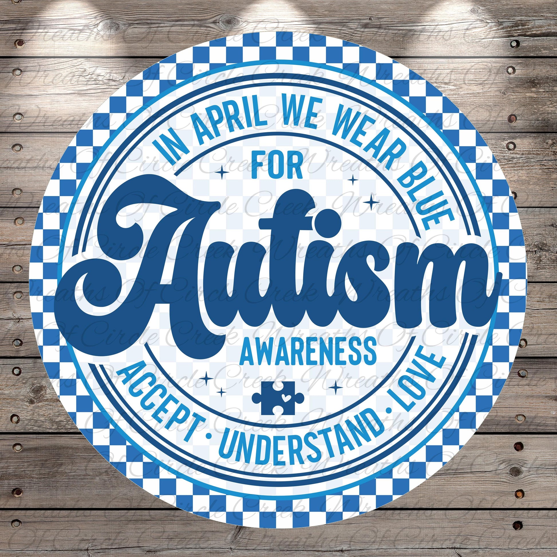 a circular design with a checkered border and a blue and white color scheme. The central message on the design reads "Autism Awareness Accept Love", and there is a puzzle piece symbol in the bottom right corner.