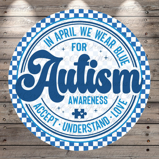 a circular design with a checkered border and a blue and white color scheme. The central message on the design reads "Autism Awareness Accept Love", and there is a puzzle piece symbol in the bottom right corner.