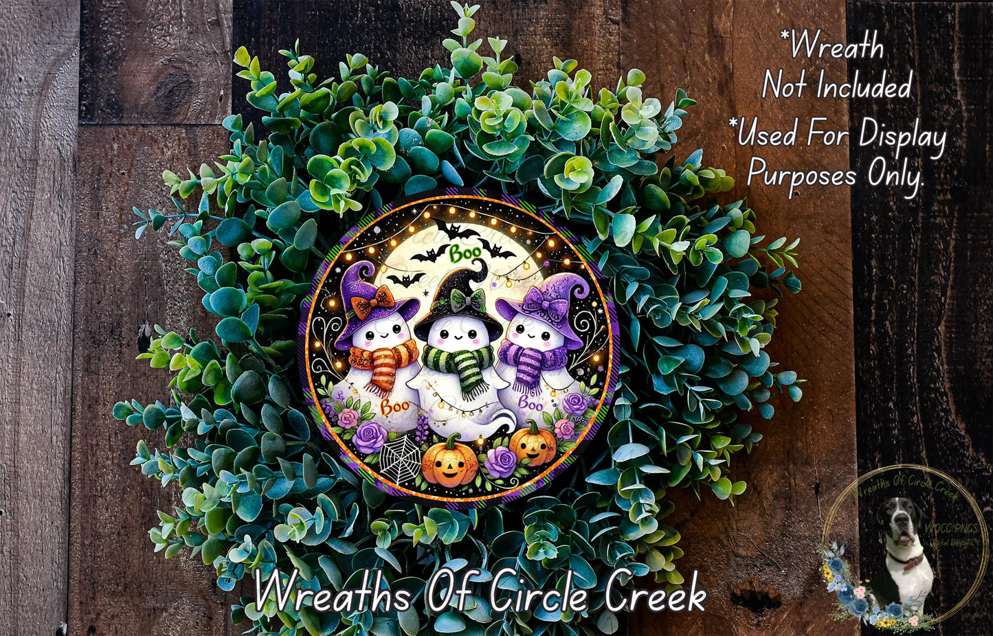A Halloween-themed wreath made of green foliage and featuring three small, whimsical characters dressed in costumes.