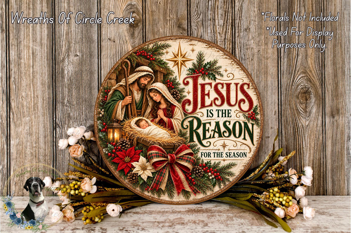 A round wooden sign with a nativity scene and the text "Jesus is the Reason for the Season" is displayed on a wooden surface, surrounded by a wreath of flowers and greenery.