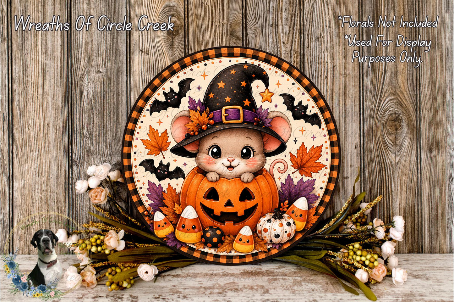 A Halloween-themed wreath featuring a cartoon mouse wearing a witch's hat, sitting inside a carved pumpkin surrounded by candy canes, leaves, and bats.