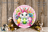 A round, decorative Easter wreath with a white bunny holding colorful Easter eggs, surrounded by a floral arrangement and a banner that reads "Happy Easter".