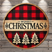 A circular wooden sign with a red and black plaid pattern, featuring the text "MERRY CHRISTMAS" in bold black letters. The sign is surrounded by three wooden Christmas trees, creating a festive and holiday-themed design.