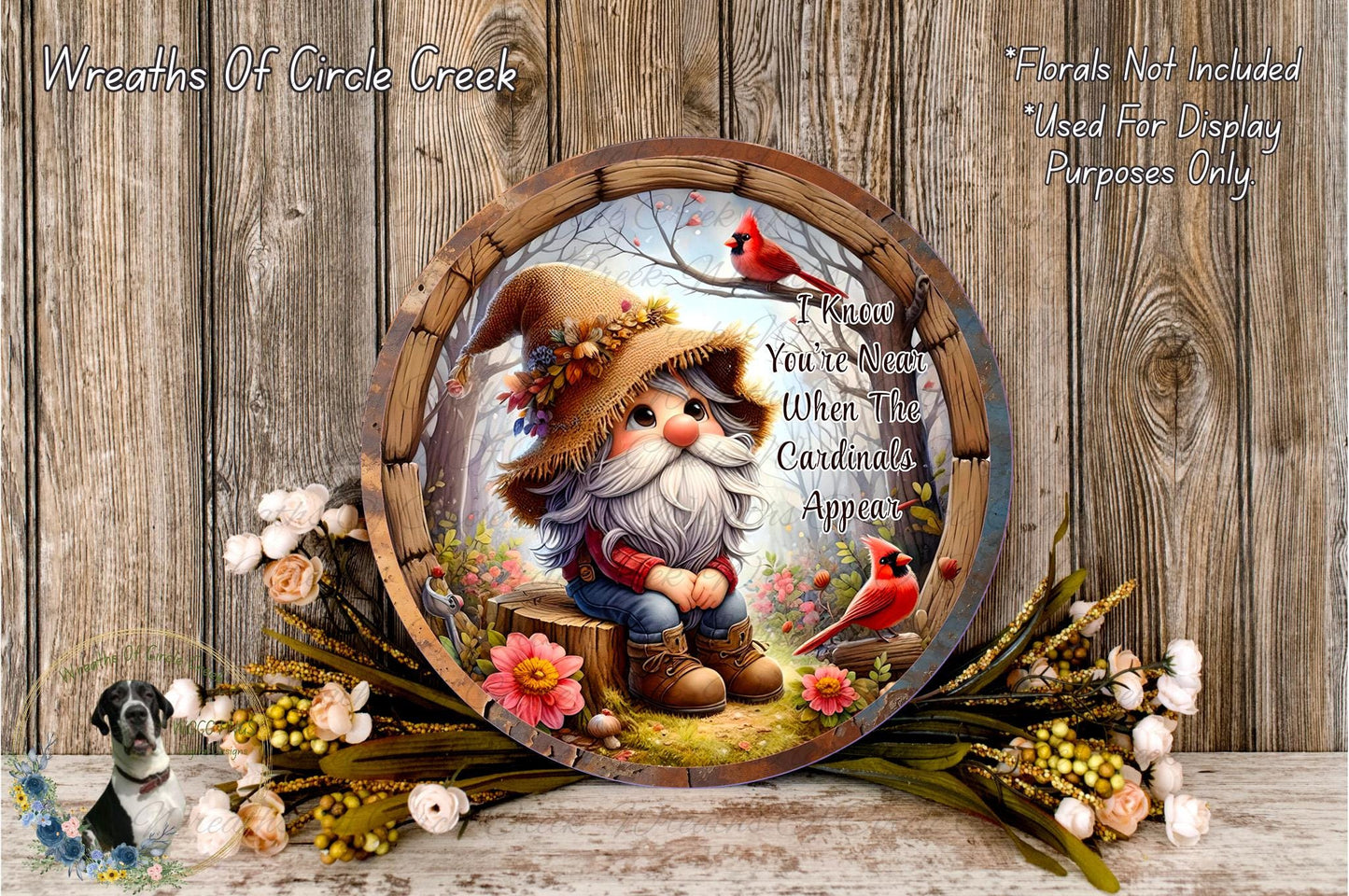 A round wooden plate with a gnome wearing a hat and holding a flower, surrounded by a floral arrangement and a bird.