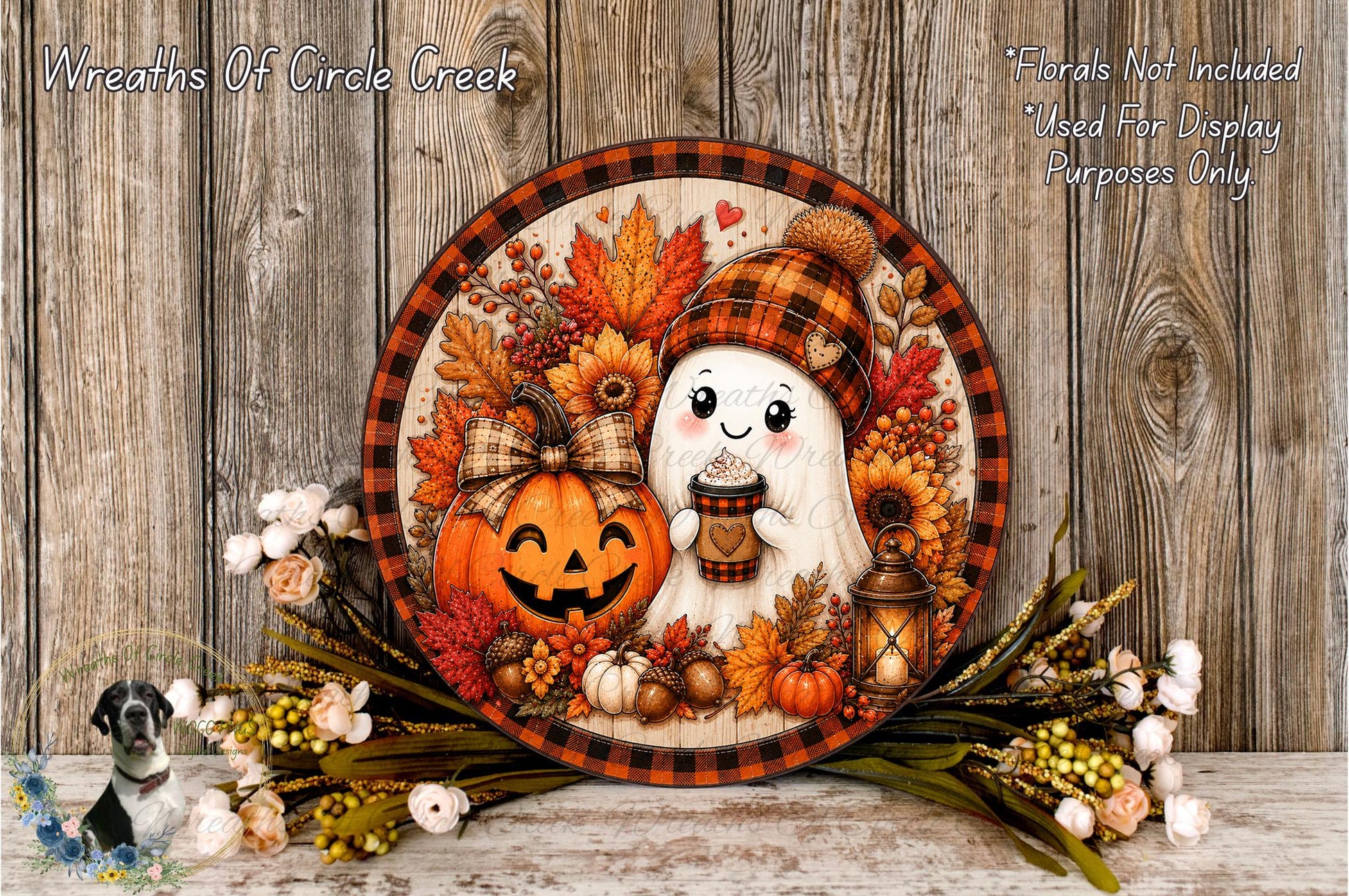 A Halloween-themed wreath with a pumpkin, ghost, and other fall decorations, including flowers and a lantern, is displayed on a wooden surface.