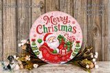 A festive Christmas-themed sign with Santa Claus riding a sleigh pulled by presents, surrounded by holiday decorations such as flowers and greenery.