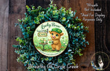 a wreath with a sign for "Lucky Brew Cafe" and a small cat wearing a hat. The wreath is surrounded by greenery, and there is a small dog in the bottom right corner.