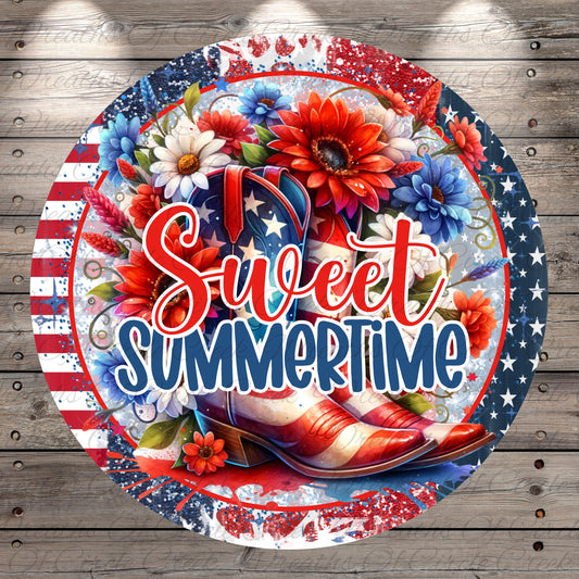 A circular design featuring a vibrant floral arrangement with red, white, and blue colors, along with a pair of red and white cowboy boots. The text "Sweet Summertime" is prominently displayed in the center of the design.