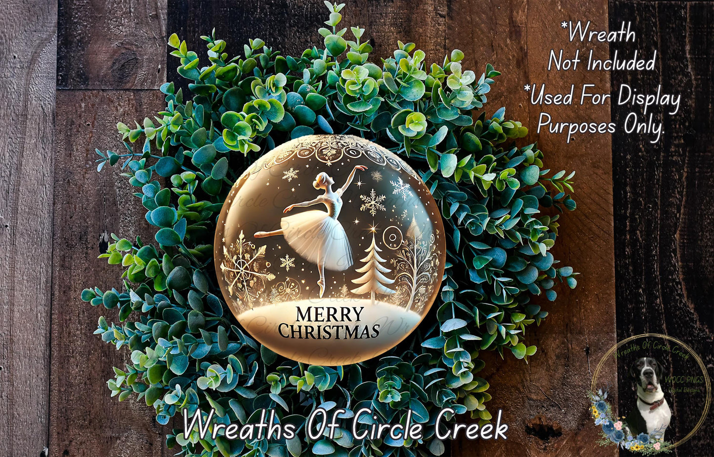 A wreath made of green foliage and a glass snow globe with a ballerina figure inside, set against a wooden background.