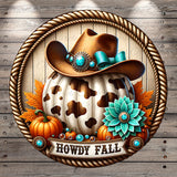A cowboy hat with a turquoise ribbon and a cowhide pumpkin, surrounded by autumn leaves and pumpkins, with the text "HOWDY FALL" displayed below.