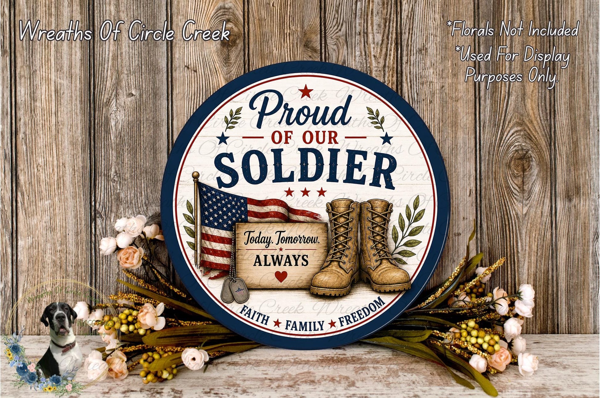 a patriotic sign that reads "Proud of our SOLDIER" with an American flag and a pair of boots, surrounded by flowers and a wreath.