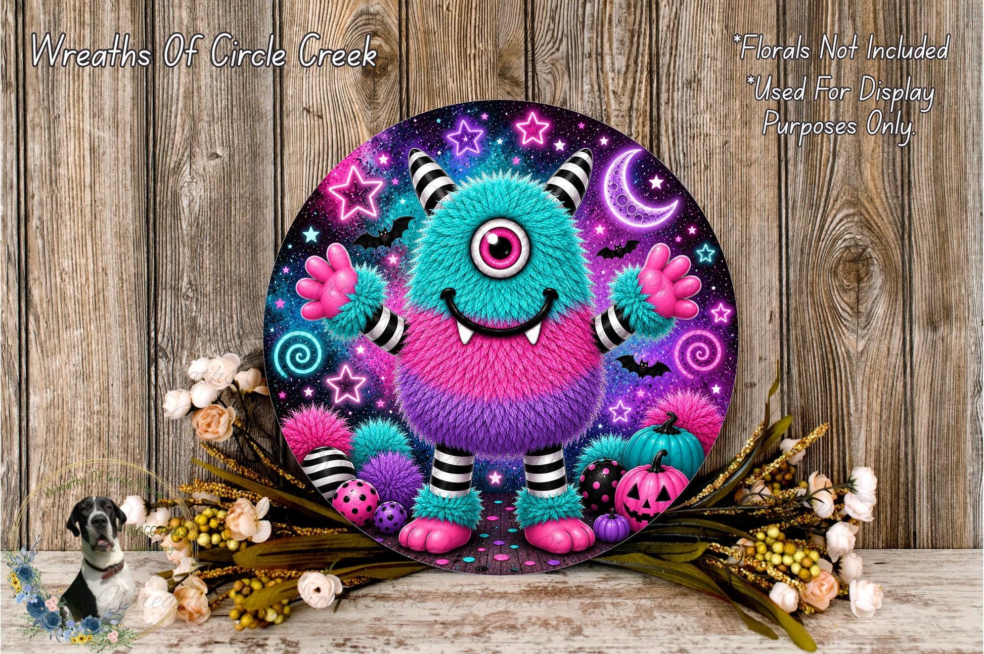 A whimsical, colorful monster-themed wreath with a starry night sky background, surrounded by flowers and pumpkins.