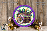 a decorative plate with a vibrant design of a drum surrounded by colorful feathers and flowers, placed on a wooden surface.