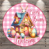 A whimsical illustration of a bunny peeking out from a colorful Easter-themed house, surrounded by decorated Easter eggs. The text "Every Bunny Welcome" is displayed in a pink and white checkered pattern, creating a festive and cheerful atmosphere.