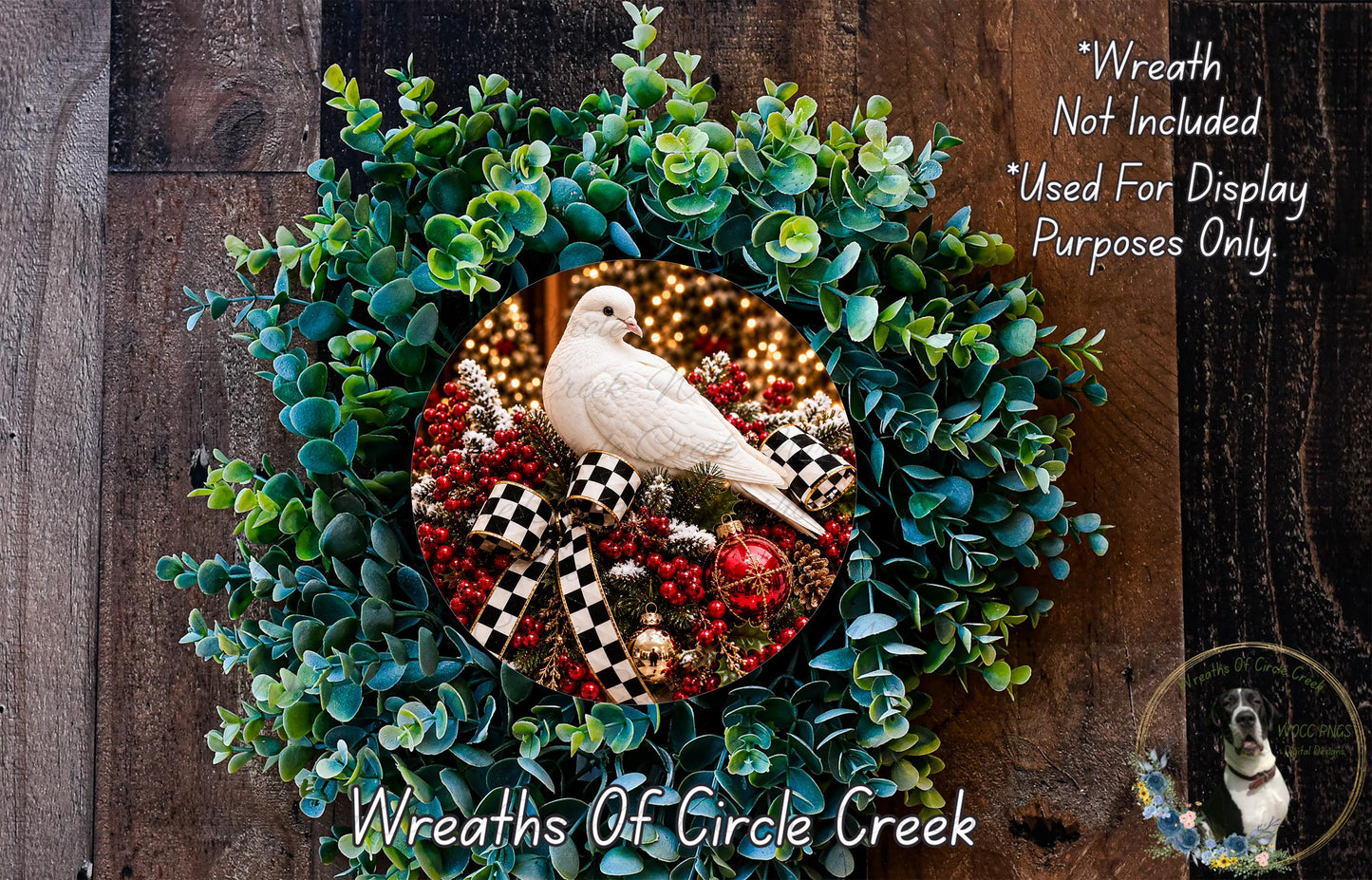 A wreath made of green leaves and red berries, with a white bird perched on top. The wreath is displayed on a wooden surface.