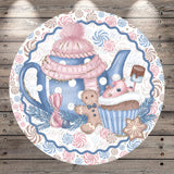 A decorative plate featuring a teapot, cupcake, gingerbread man, and snowflake, all set against a background of swirling patterns in shades of blue, pink, and white.