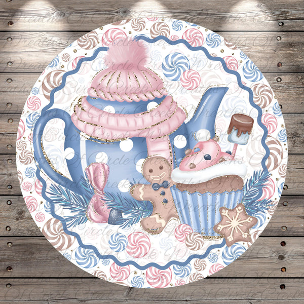 A decorative plate featuring a teapot, cupcake, gingerbread man, and snowflake, all set against a background of swirling patterns in shades of blue, pink, and white.