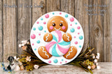 A gingerbread man figure holding a colorful candy cane is displayed on a white circular board, surrounded by a floral arrangement and placed on a wooden surface.