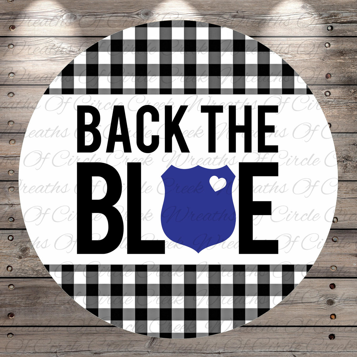 a circular design with a black and white checkered pattern and a blue shield with a heart symbol in the center. The text "BACK THE BLUE" is prominently displayed in the center of the design.