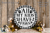 a decorative sign with the text "All My Kids Have Paws" displayed on a wooden surface. The sign is surrounded by a floral arrangement, and there is text in the top left corner that reads "Wreaths Of Circle Creek".