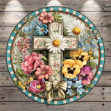 A decorative cross surrounded by a vibrant arrangement of colorful flowers, including daisies, pansies, and other blooms, set against a rustic wooden background.