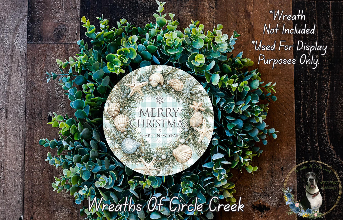 A wreath made of various green and blue foliage, with a circular sign in the center that reads "Merry Christmas Happy New Year". The wreath is displayed on a wooden surface, and there is a text overlay that says "Wreath Not Included * Used For Display Purposes Only".