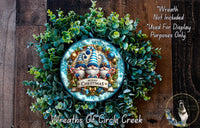 A wreath made of green foliage and featuring a decorative plate with a gnome design, surrounded by a text overlay that reads "Merry Christmas" and "Wreaths of Circle Creek".