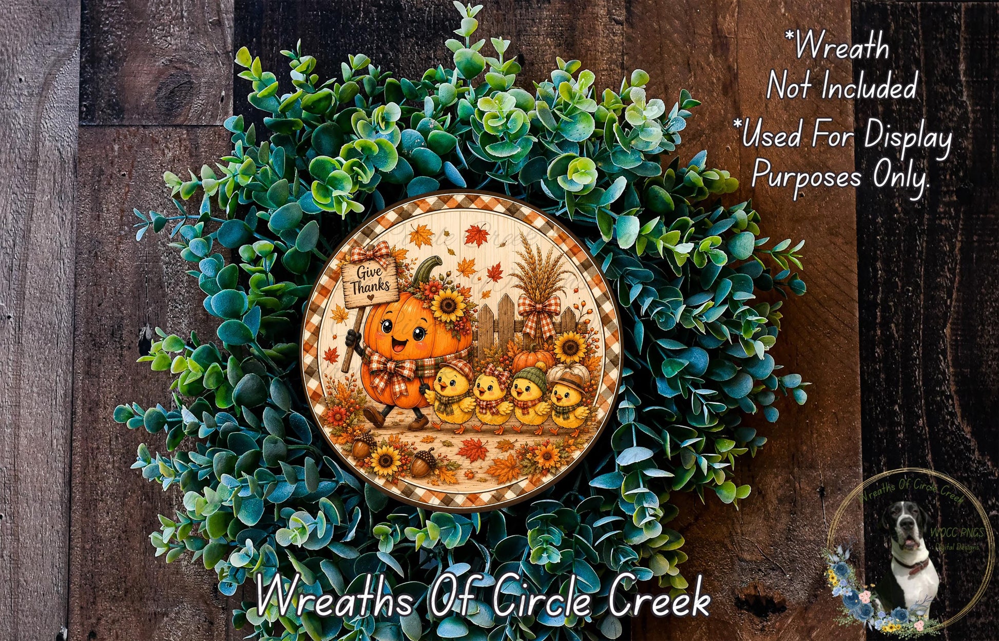 A wreath made of green leaves and a pumpkin with a sign that says "Give thanks" is displayed on a wooden surface.