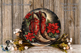 A decorative wreath featuring red cowboy boots and red poinsettias, set against a wooden background with white flowers.