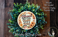 A wreath made of various green and brown foliage, with a circular plaque featuring a quote about trust and the Lord.