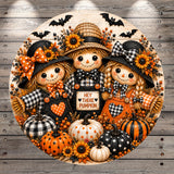 A decorative round wreath featuring three scarecrow dolls, pumpkins, and sunflowers, with the text "Hey there pumpkin" displayed on the wreath.