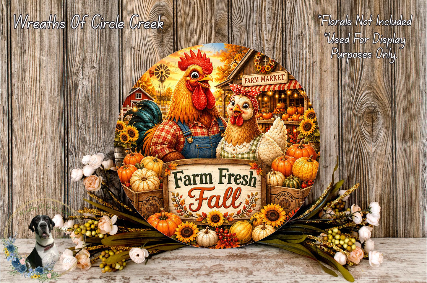 A decorative plate featuring a rooster, a chicken, and various fall-themed elements such as pumpkins, sunflowers, and a sign that says "Farm Fresh Fall". The plate is surrounded by a floral arrangement and placed on a wooden surface.