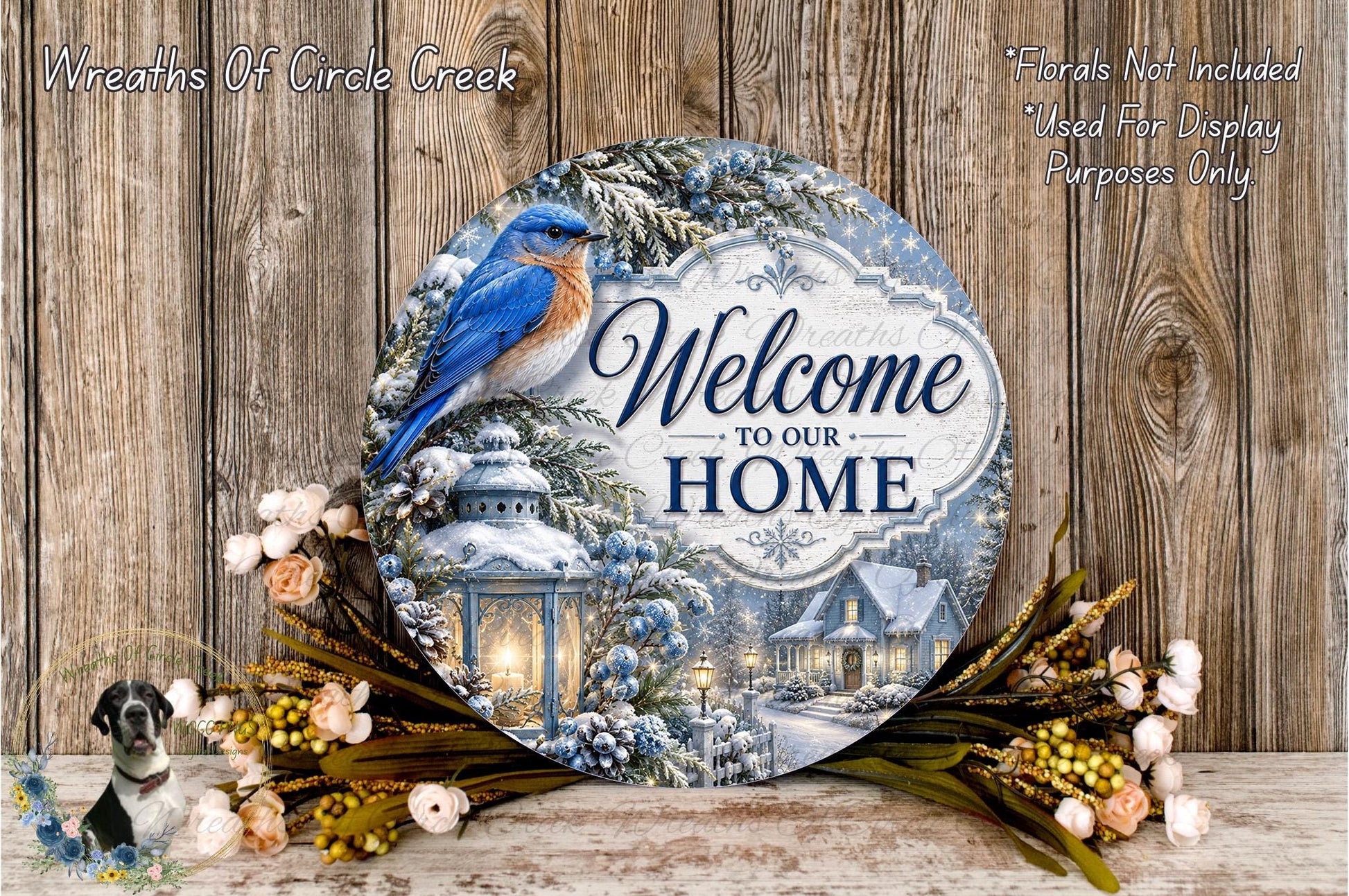 A decorative sign with a blue bird perched on a snowy landscape, surrounded by flowers and greenery, with the text "Welcome to our Home" prominently displayed.