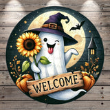 A whimsical Halloween-themed sign featuring a ghost holding a sunflower, a wooden sign with the word "WELCOME", and a castle in the background.