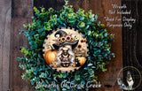A wreath featuring a cartoon illustration of a witch surrounded by pumpkins and flowers, with the text "Happy Halloween" on it.