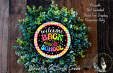 a wreath made of green plants and a colorful sign that says "Welcome Back to School".