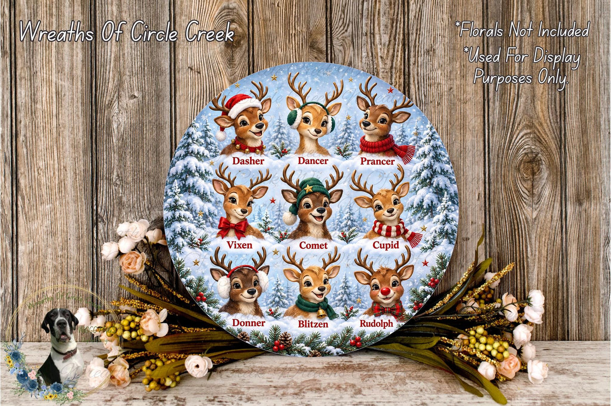 A circular arrangement of nine deer heads, each with a different name, against a snowy winter landscape background. The deer are dressed in various winter attire, including Santa hats, scarves, and other festive accessories. The arrangement is surrounded by a wreath of flowers and greenery, creating a festive and holiday-themed display.