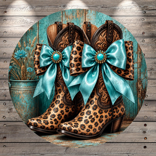 A pair of leopard-print cowboy boots with blue bows, set against a rustic wooden background.