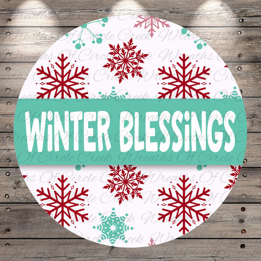 A circular sign with the text "Winter Blessings" in large white letters, surrounded by red and green snowflakes on a white background.