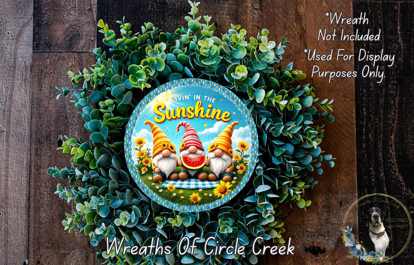 a wreath with a gnome design, surrounded by greenery and flowers. The wreath is placed on a wooden surface.