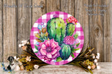 a round, pink and white checkered plate with a vibrant floral arrangement of cacti and flowers, placed on a wooden surface.