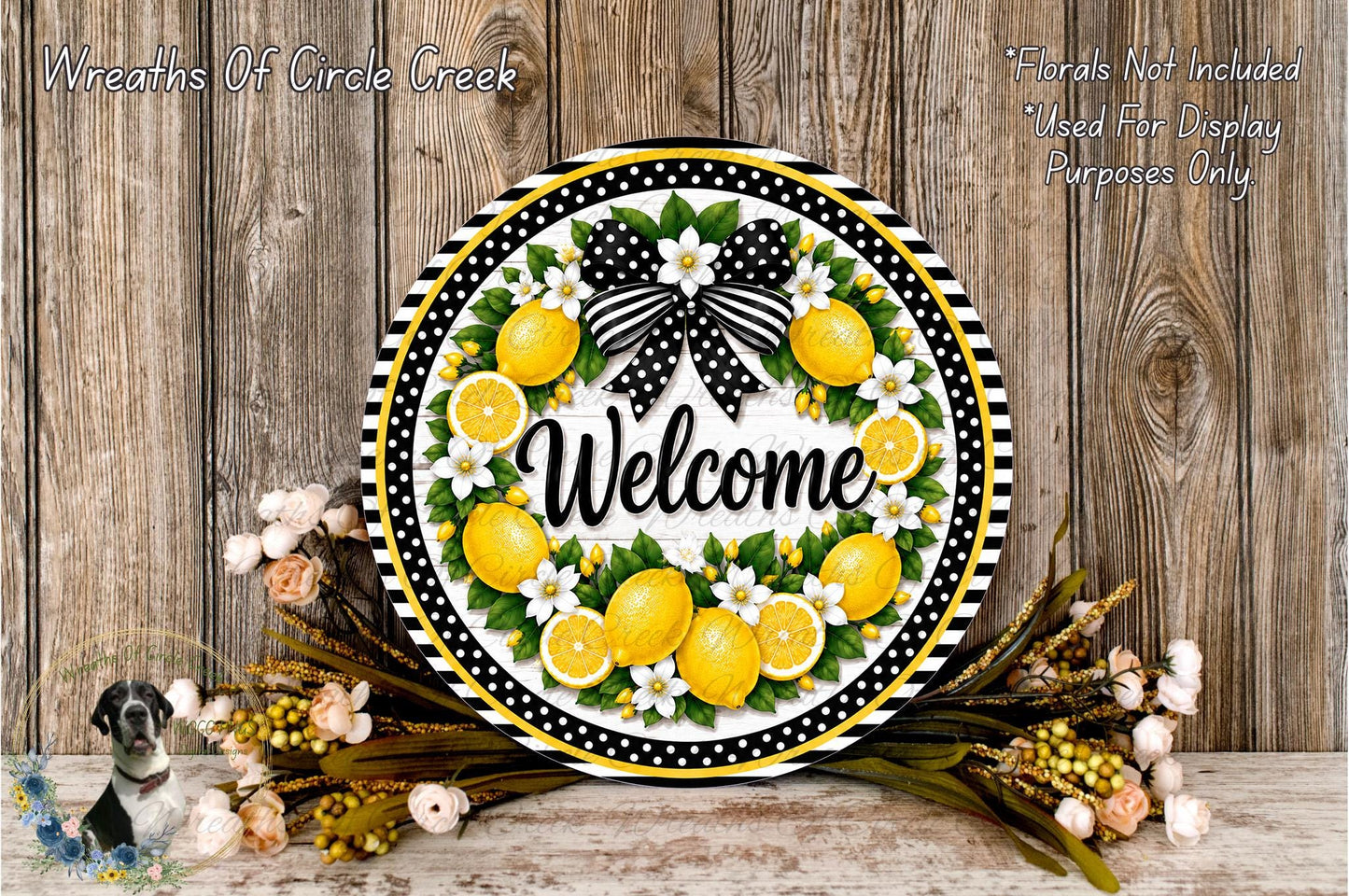 A decorative wreath with a welcoming message, surrounded by flowers and placed on a wooden surface.