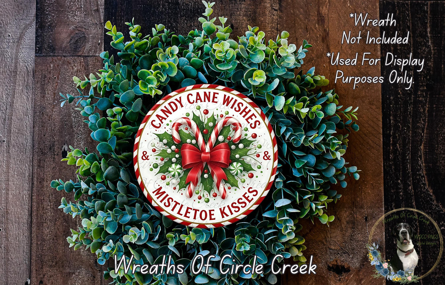 A wreath made of green leaves and red and white ribbons, with a circular sign that says "Candy Cane Wishes Mistletoe Kisses" in the center.