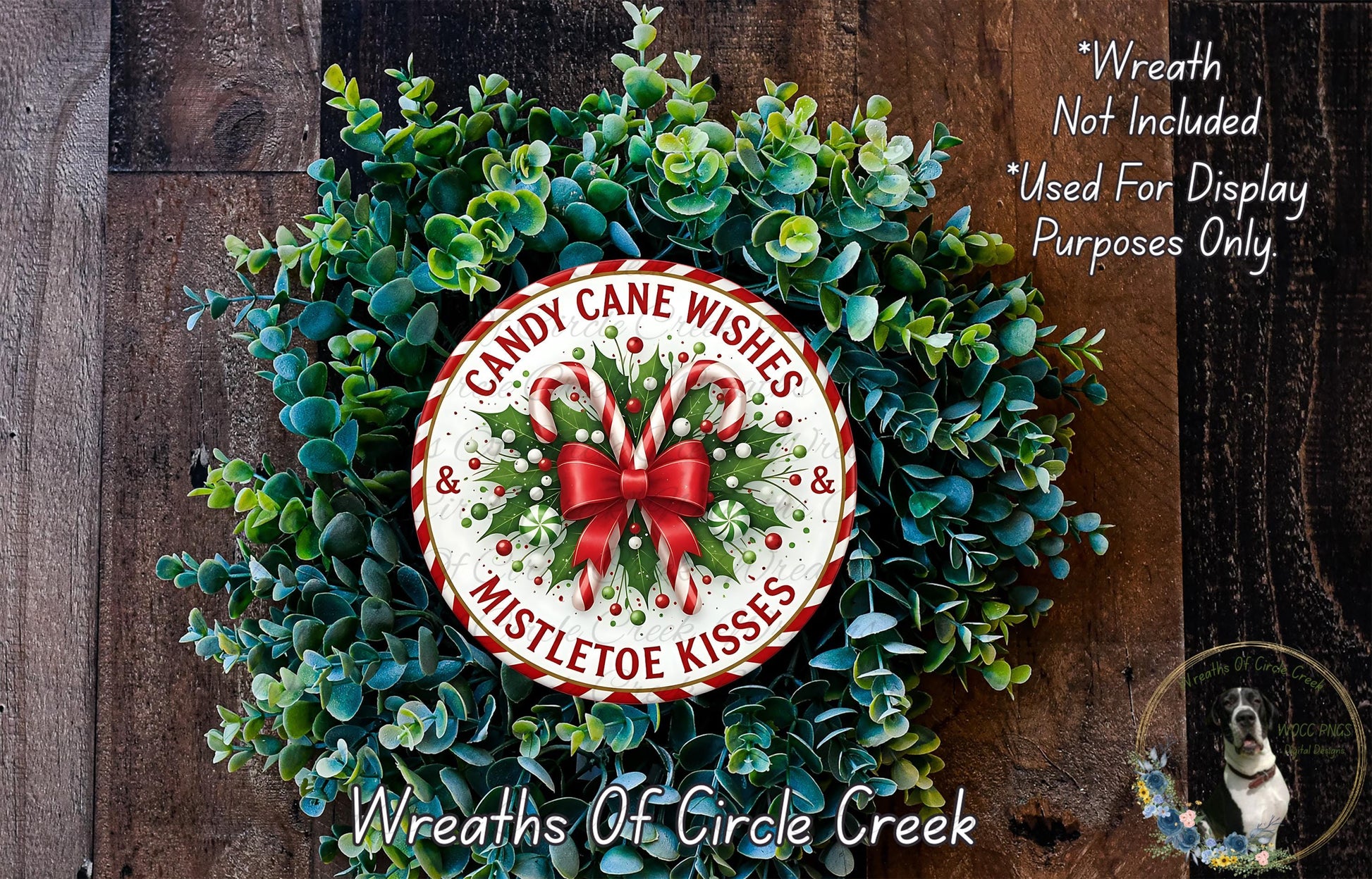 A wreath made of green leaves and red and white ribbons, with a circular sign that says "Candy Cane Wishes Mistletoe Kisses" in the center.