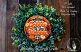 a wreath made of various fall-themed elements, including pine cones, pumpkins, and greenery, with a large orange circular sign that says "Gobble till you worry".