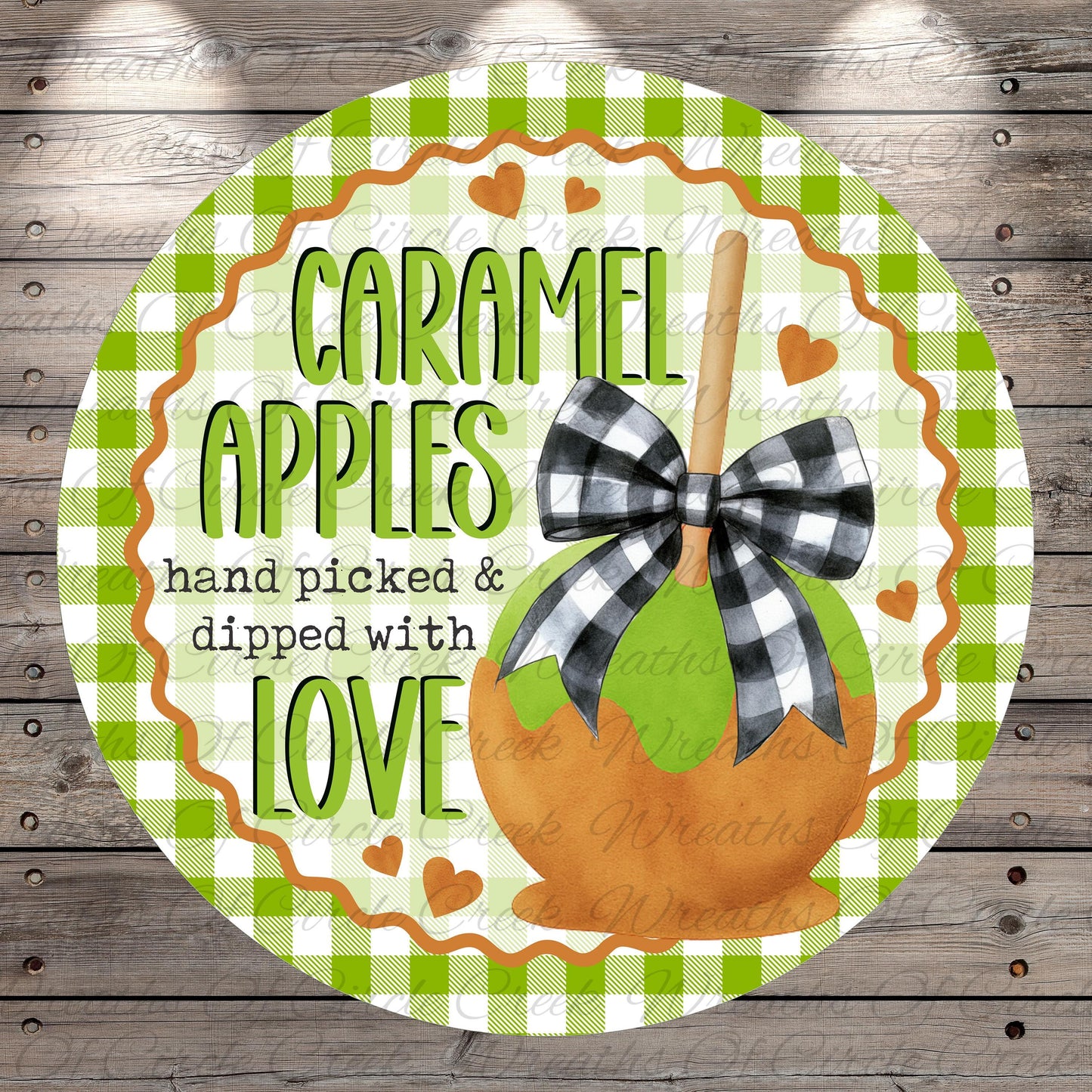 a round sign with a caramel apple design, surrounded by a green and white checkered border. The sign has a bow on top of the caramel apple and the text "CARAMEL APPLES hand picked & dipped with love" written on it.