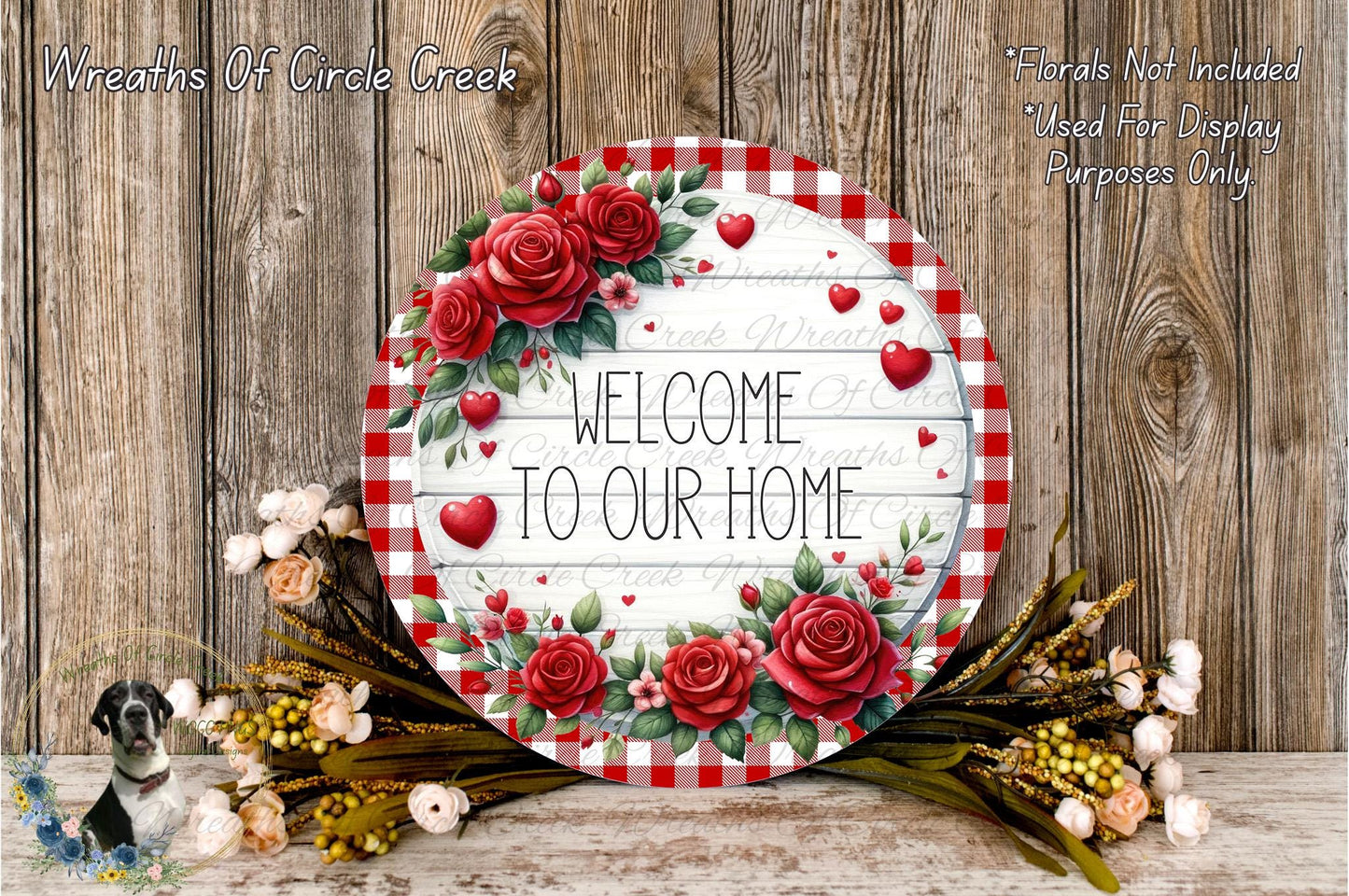 a round sign with a floral design, surrounded by a wreath of flowers and greenery, placed on a wooden surface.