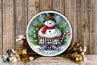 A snowman wearing a top hat and scarf, sitting in a cupcake with a red and white striped candy cane, surrounded by pine branches and flowers, with the text "LET IT SNOW" on a wooden background.