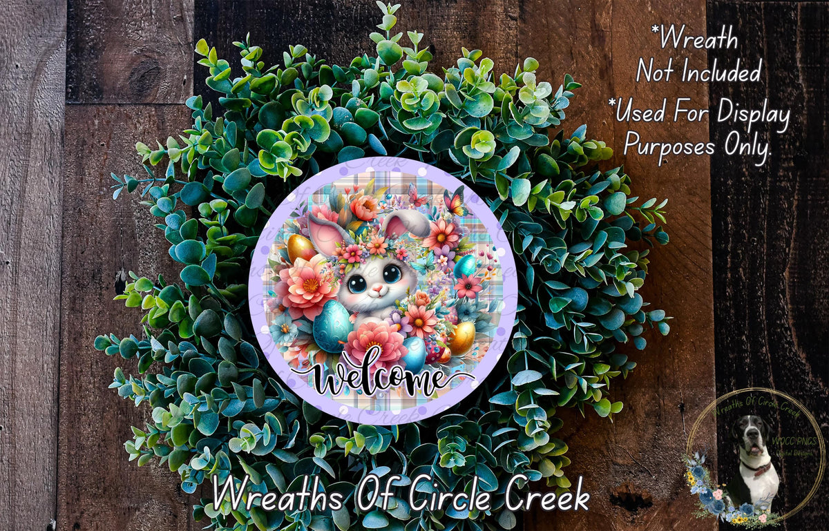 a wreath with a bunny and flowers, surrounded by greenery, and a sign that reads "Welcome" in the center.